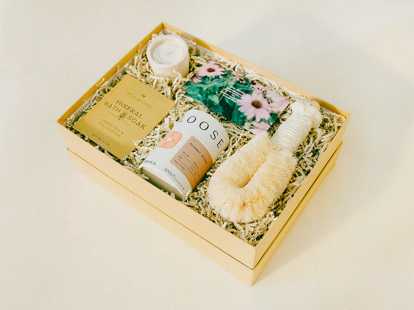 Luxury giftbox containing relaxing bath products, specialty chocolate, tea, and a candle.