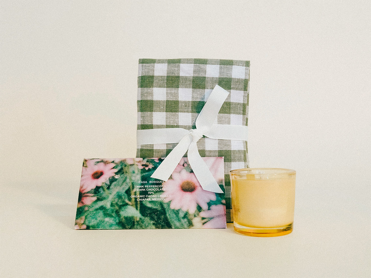 Gift with products for a housewarming specialty chocolate, a candle, and a gingham tea tea.