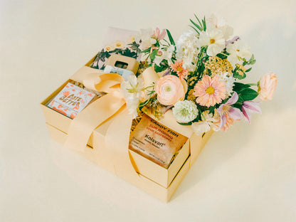 Gift box with specialty candy, chocolate, and flower arrangement. 