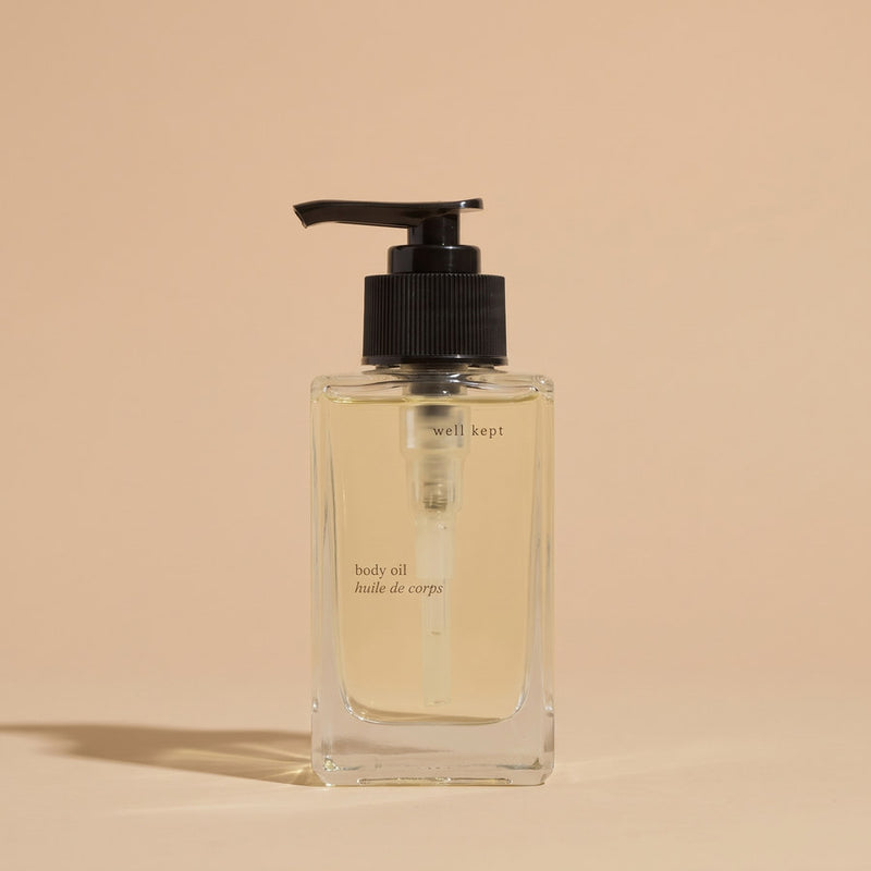 Well Kept body oil in a clear glass bottle with a black pump
